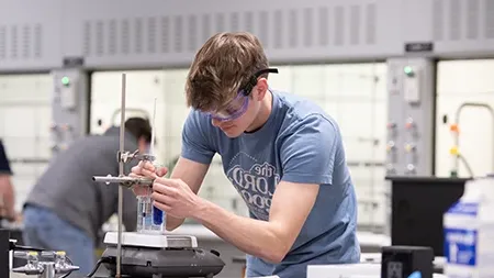 在科学实验室操作设备的男学生.